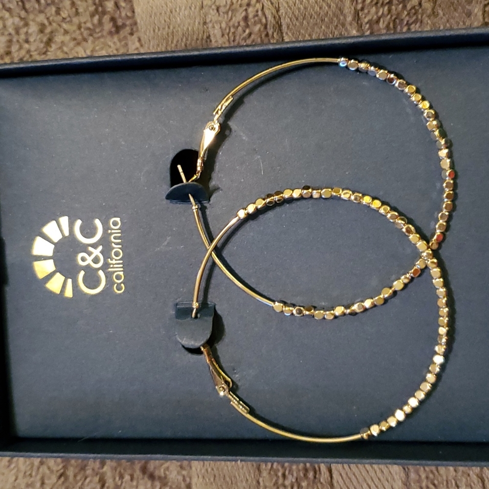 Silver hoop earrings they have small shiny beads on them